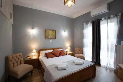 a bedroom with a bed and a chair and a window at Danaï house in Athens