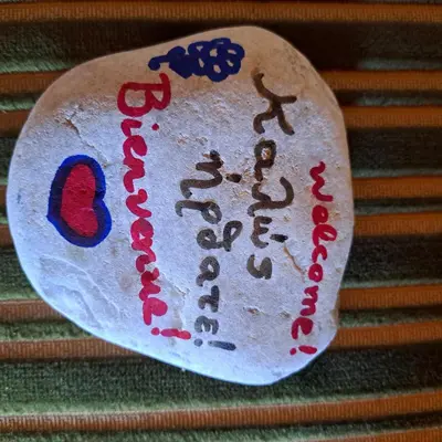a rock with writing on it on top of stairs at Danaï house in Athens