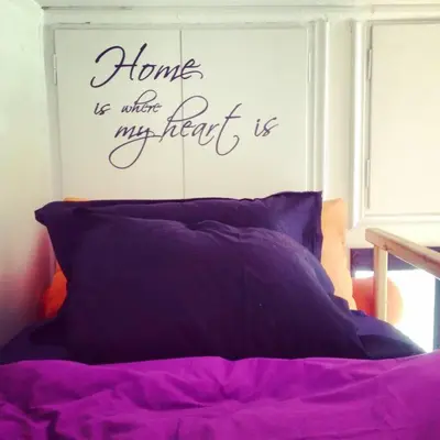 a bed with purple sheets and a sign on a wall at Rooftop Athens Central Studio in Athens