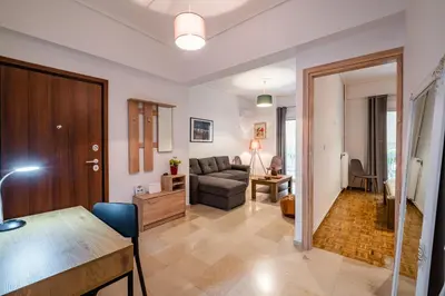 a living room with a couch and a table at SOKOS Residence, 1' walk from Aghios Ioannis Metro in Athens