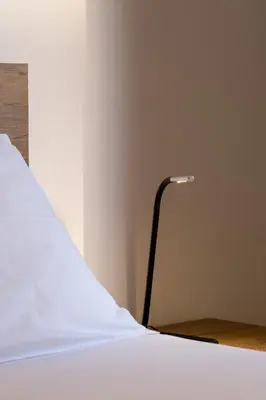 a bed with a white sheet and a lamp at SOKOS Residence, 1' walk from Aghios Ioannis Metro in Athens