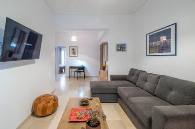 a living room with a couch and a table at SOKOS Residence, 1' walk from Aghios Ioannis Metro in Athens