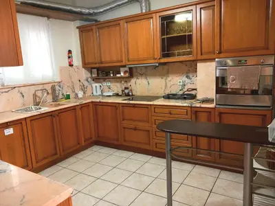a kitchen with wooden cabinets and a table in it at Athens Cityscape in Athens