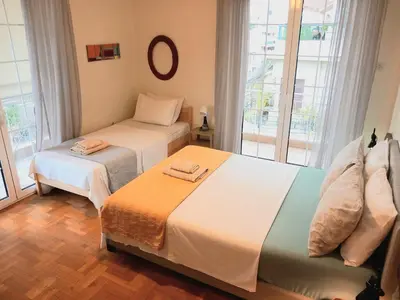 two beds in a room with windows at Athens Cityscape in Athens