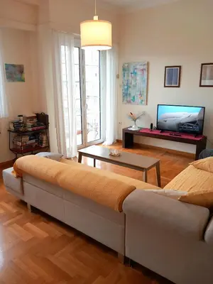 a living room with a couch and a flat screen tv at Athens Cityscape in Athens