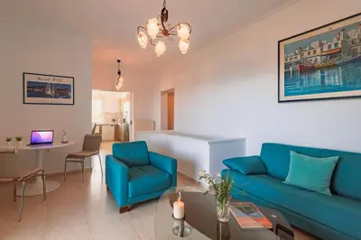 a living room with a blue couch and a table at Eternal Summer Time Villa for 6 by Filos Inc in Dhaskalión