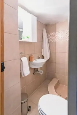 a small bathroom with a toilet and a sink at Eternal Summer Time Villa for 6 by Filos Inc in Dhaskalión
