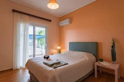 a bedroom with a large bed and a window at Eternal Summer Time Villa for 6 by Filos Inc in Dhaskalión