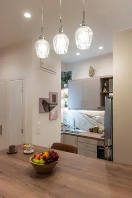 a kitchen with a table with a bowl of fruit on it at Blue Ark Acropolis Compass in Athens