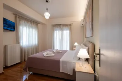 a bedroom with a bed and a table with a lamp at Blue Ark Acropolis Compass in Athens