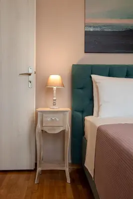 a bedroom with a bed and a lamp on a night stand at Blue Ark Acropolis Compass in Athens