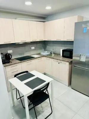 a kitchen with a white table and a refrigerator at Harmony apartment next to the Acropolis museum in Athens