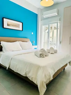 a bedroom with a large bed with a blue wall at Harmony apartment next to the Acropolis museum in Athens