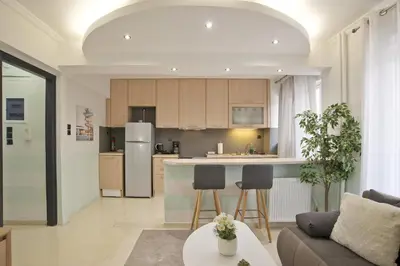 a kitchen and living room with a couch and a table at Blue Dream Modern Piraeus Apt, Walk to Beach in Piraeus