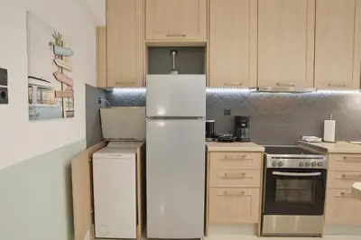 a kitchen with a white refrigerator and a stove at Blue Dream Modern Piraeus Apt, Walk to Beach in Piraeus