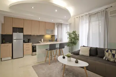 a living room and kitchen with a couch and a table at Blue Dream Modern Piraeus Apt, Walk to Beach in Piraeus
