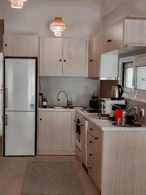 a kitchen with white cabinets and a white refrigerator at Bohemian Apartment in Central Athens in Athens