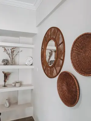 three wicker baskets hanging on a wall with a mirror at Bohemian Apartment in Central Athens in Athens