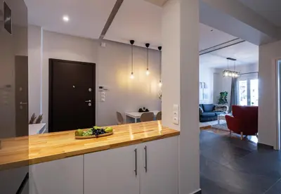 a kitchen with a counter top and a living room at Cozy & modern apartment near Panathenaic Stadium in Athens