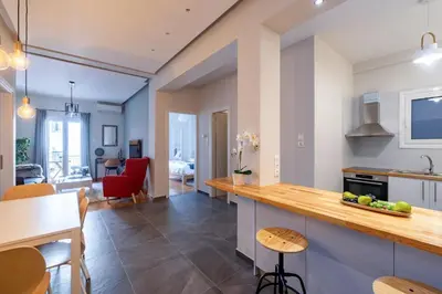 a kitchen and living room with a table and chairs at Cozy & modern apartment near Panathenaic Stadium in Athens