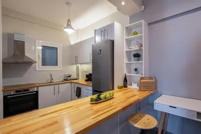 a kitchen with a wooden counter and a refrigerator at Cozy & modern apartment near Panathenaic Stadium in Athens