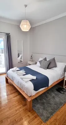 a bedroom with a large bed with a blue and white blanket at Cozy & modern apartment near Panathenaic Stadium in Athens