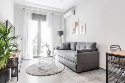 a living room with a couch and a table at Sublime 1BR Apartment in Koukaki by UPSTREET in Athens