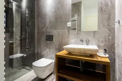 a bathroom with a sink and a toilet and a shower at Sublime 1BR Apartment in Koukaki by UPSTREET in Athens