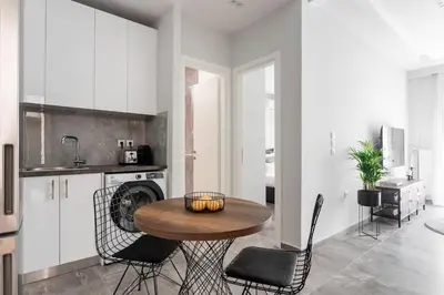a kitchen with a table and chairs in a room at Sublime 1BR Apartment in Koukaki by UPSTREET in Athens