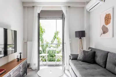 a living room with a couch and a television at Sublime 1BR Apartment in Koukaki by UPSTREET in Athens