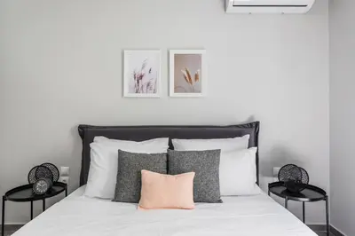 a bedroom with a white bed with a pink pillow at Sublime 1BR Apartment in Koukaki by UPSTREET in Athens