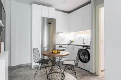 a kitchen with a table and chairs and a washing machine at Sublime 1BR Apartment in Koukaki by UPSTREET in Athens
