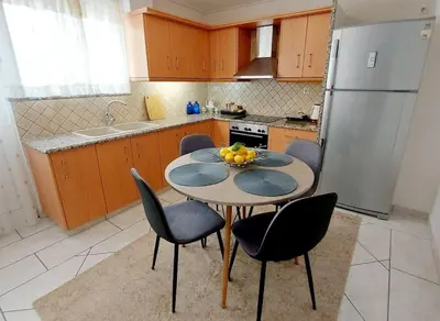 a kitchen with a table with chairs and a refrigerator at Inspiration Alimos Getaway, close to the beach in Athens