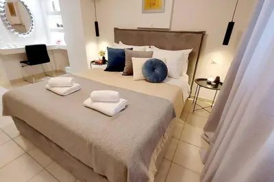 a bedroom with a large bed with towels on it at Inspiration Alimos Getaway, close to the beach in Athens