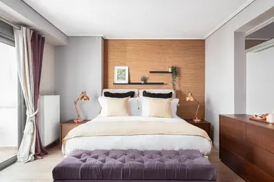 a bedroom with a large bed with a purple ottoman at Glyfada Luxury Living in Athens
