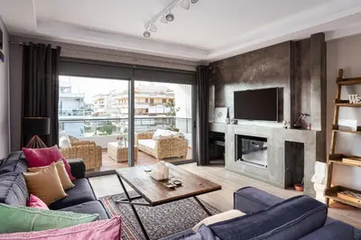 a living room with a couch and a fireplace at Glyfada Luxury Living in Athens