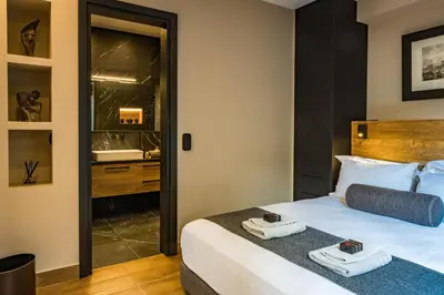 a bedroom with a large bed and a bathroom at Aeanos suite in Athens
