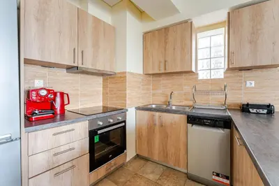 a kitchen with wooden cabinets and a red appliance at Lux & Style 75sqm with Private Parking in Athens in Athens