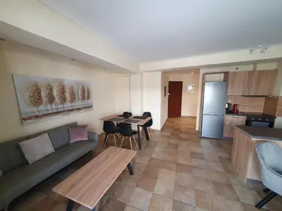 a living room with a couch and a table and a kitchen at Lux & Style 75sqm with Private Parking in Athens in Athens