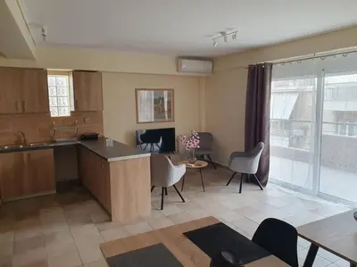 a kitchen with a table and chairs in a room at Lux & Style 75sqm with Private Parking in Athens in Athens