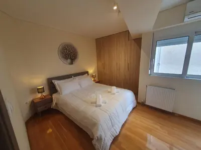 a bedroom with a bed with two candles on it at Lux & Style 75sqm with Private Parking in Athens in Athens