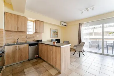 a kitchen with wooden cabinets and a dining room at Lux & Style 75sqm with Private Parking in Athens in Athens