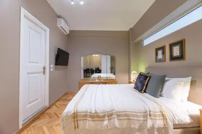 a bedroom with a large bed and a mirror at Exclusive Acropolis 4BDR Large Residence in Athens
