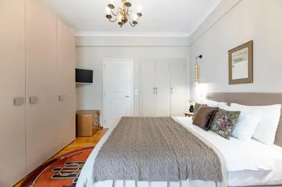 a bedroom with a large bed and a chandelier at Exclusive Acropolis 4BDR Large Residence in Athens
