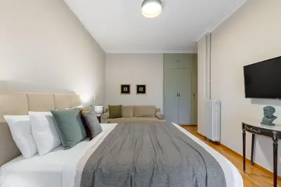 a bedroom with a large bed and a couch at Exclusive Acropolis 4BDR Large Residence in Athens