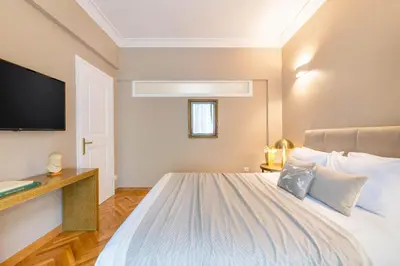 a bedroom with a bed with a tv on the wall at Exclusive Acropolis 4BDR Large Residence in Athens