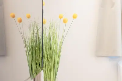 a vase with grass and yellow flowers in it at City Life Athens Apartments in Athens