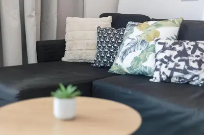 a black couch with pillows and a table at City Life Athens Apartments in Athens