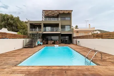 a house with a swimming pool in front of a house at Magnificent, Deluxe Villa, Lagonisi, Athens Riviera in Áyios Nikólaos
