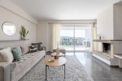 a living room with a couch and a fireplace at Serene 2BR Apartment in Alimos with Sea view by UPSTREET in Athens